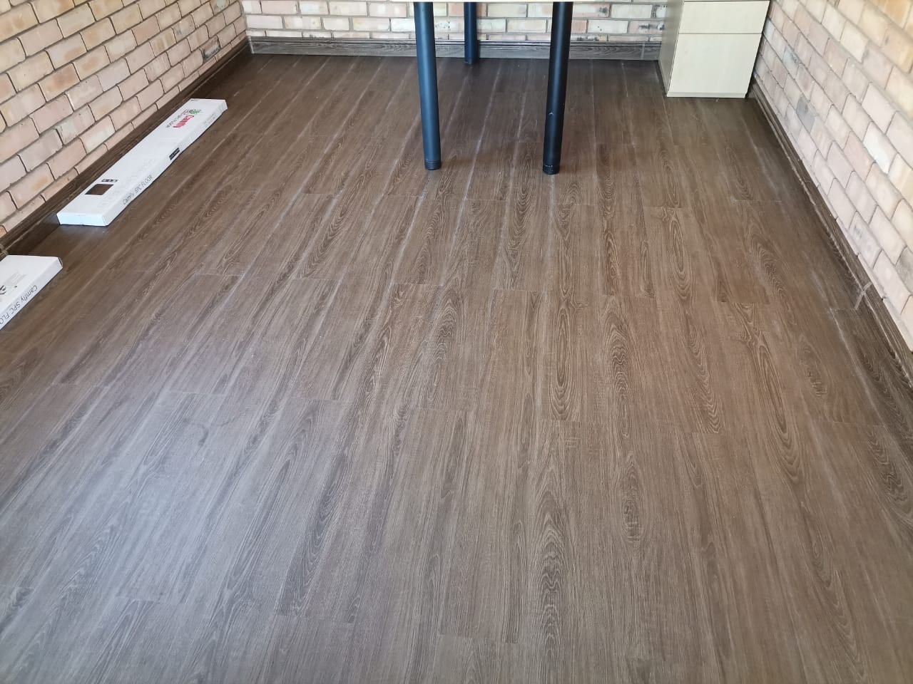 Dark oak SPC flooring in a face-brick room