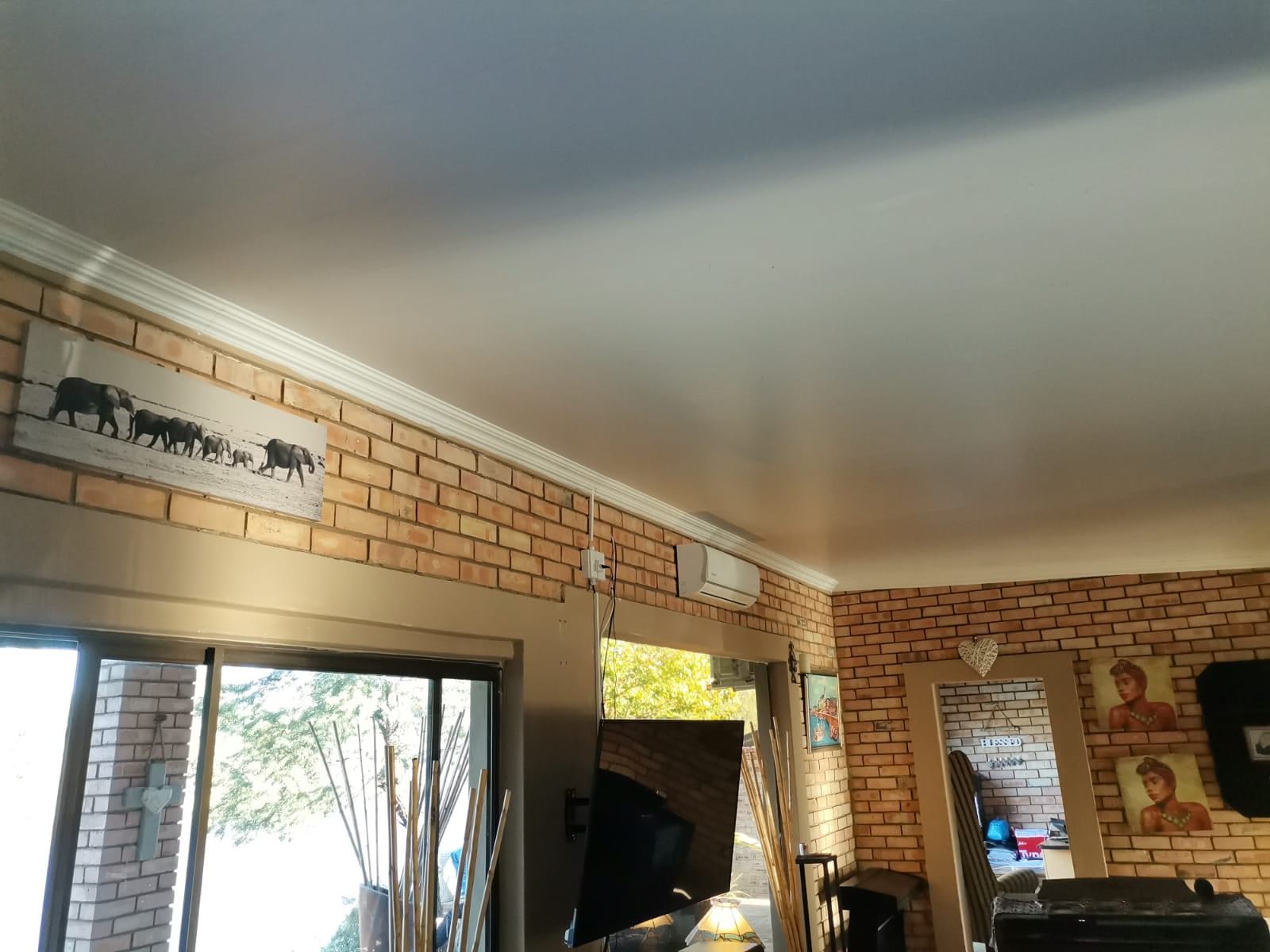 White PVC ceiling with cornice installed in a face-brick lounge