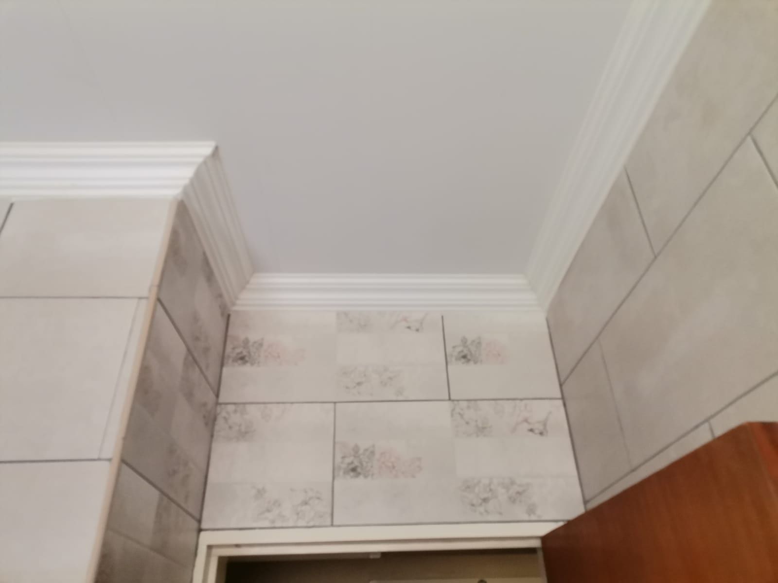 PVC ceiling with cornice in a tiled room
