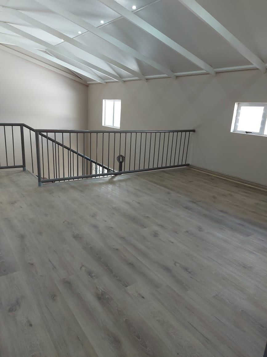 Grey oak SPC flooring in an open-plan loft with steel balustrade